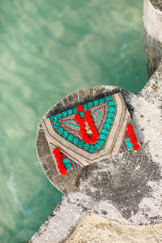 Red pompom & green stone clutch with a sling
